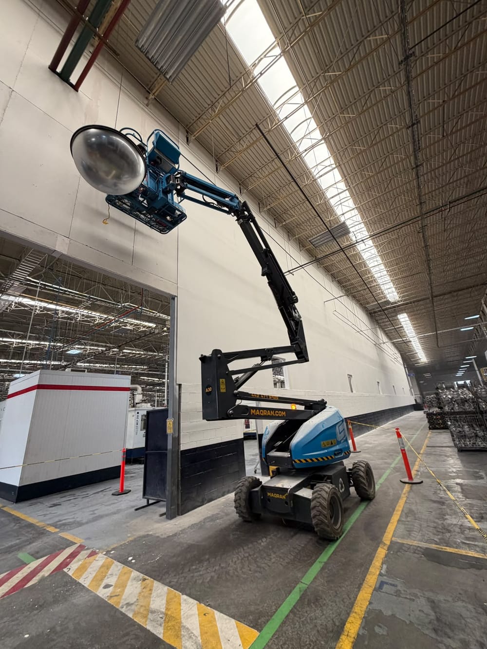 Plataforma elevadora durante la construcción de un muro divisorio en planta industrial